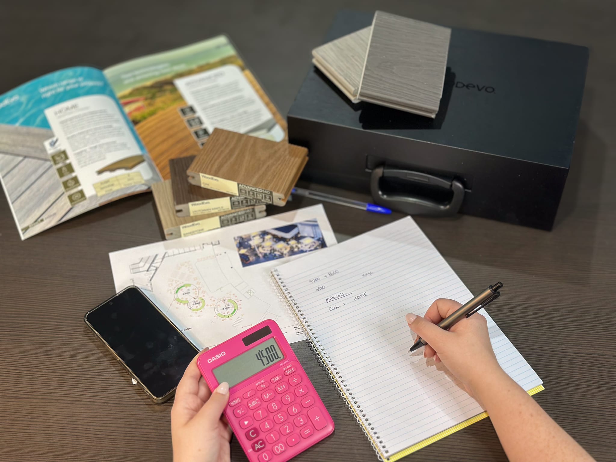 Homeowner calculating renovation costs with timber samples and flooring materials for custom wood and interior projects